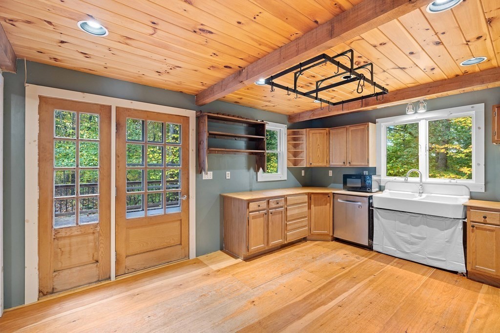 756 Bemis Road Warren, MA 01585 - Photo 12 of 41 a large kitchen with stainless steel appliances granite countertop a stove a sink dishwasher and white cabinets next to a window