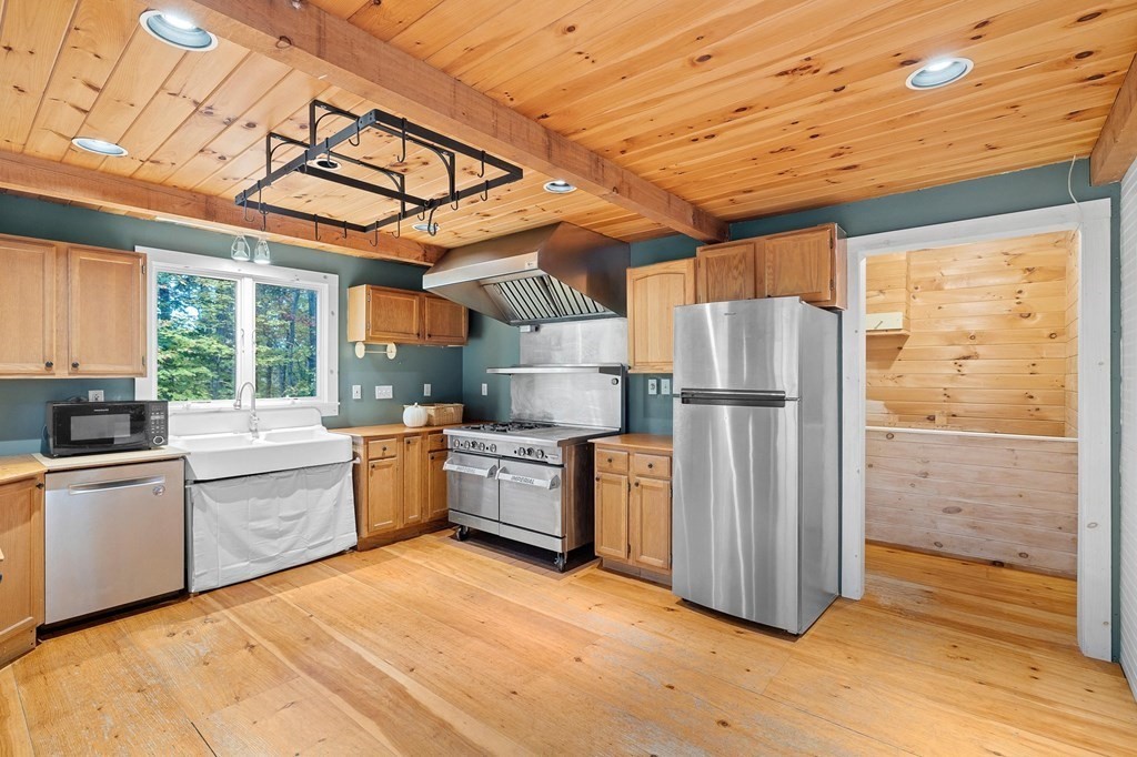 756 Bemis Road Warren, MA 01585 - Photo 13 of 41 a kitchen with refrigerator cabinets and wooden floor