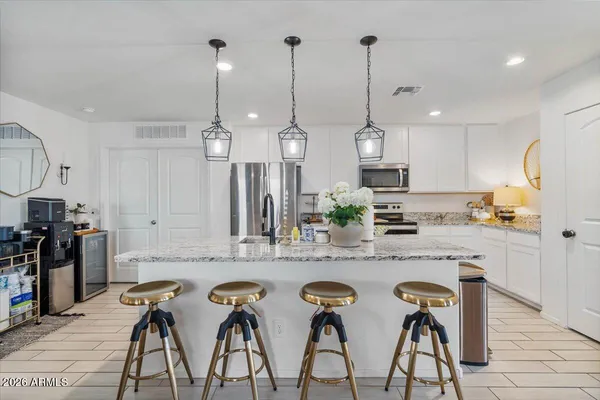 a kitchen with stainless steel appliances kitchen island a refrigerator and a sink