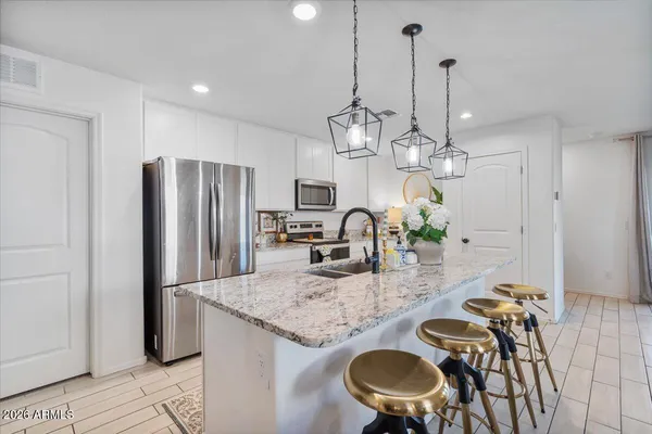 a kitchen with stainless steel appliances granite countertop sink refrigerator and microwave