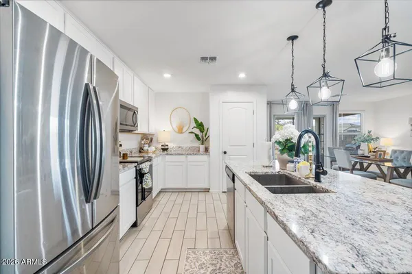 a kitchen with stainless steel appliances granite countertop a stove a sink and a refrigerator