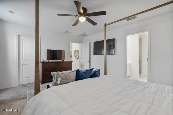 a bedroom with a bed and a flat tv screen on dresser