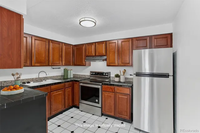 a kitchen with stainless steel appliances granite countertop a stove a sink dishwasher and a refrigerator
