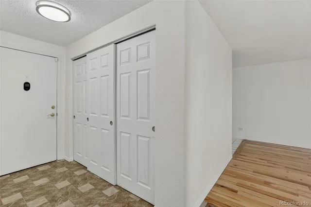 a view of a hallway with wooden floor and closet