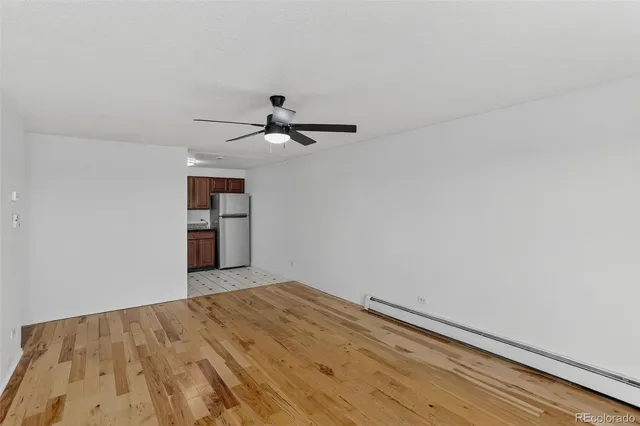 a view of empty room with a ceiling fan and window