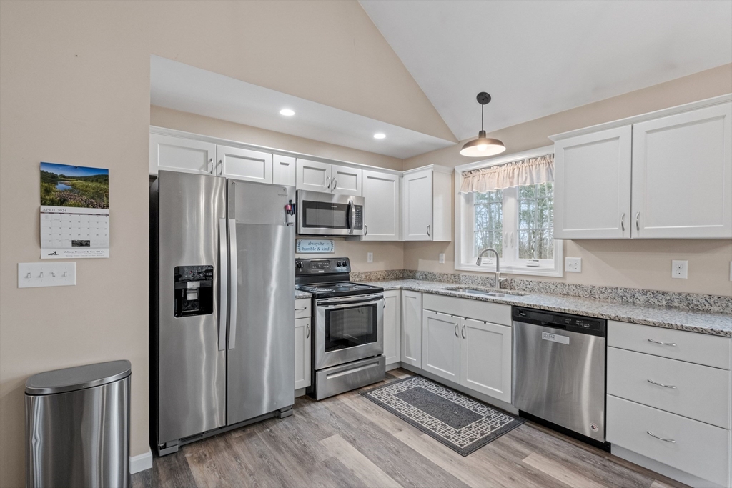 3 Fieldstone Drive Deerfield, NH 03037 - Photo 8 of 28 a kitchen with stainless steel appliances granite countertop a refrigerator a sink dishwasher a stove and white cabinets with wooden floor