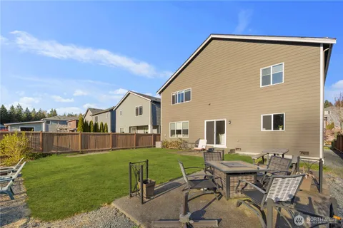 a backyard of a house with table and chairs