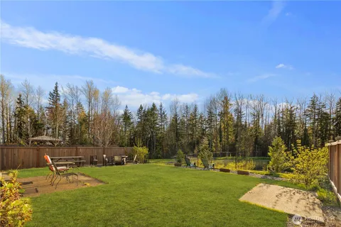 a view of a big house with a big yard and large trees