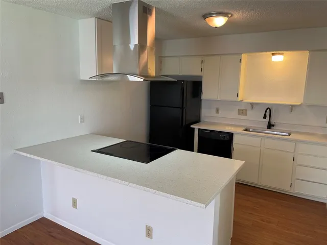 a kitchen with a sink a stove and cabinets