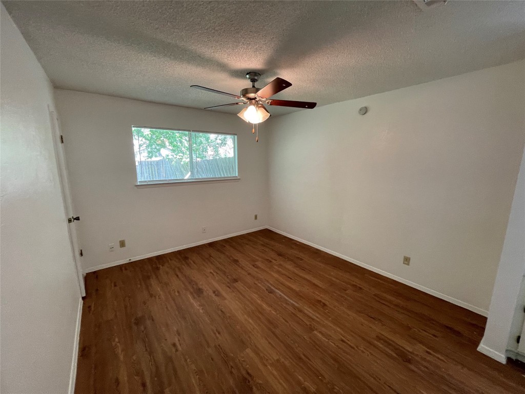 7506 St Amant Place Austin, TX 78749 - Photo 7 of 16 an empty room with wooden floor ceiling fan and windows