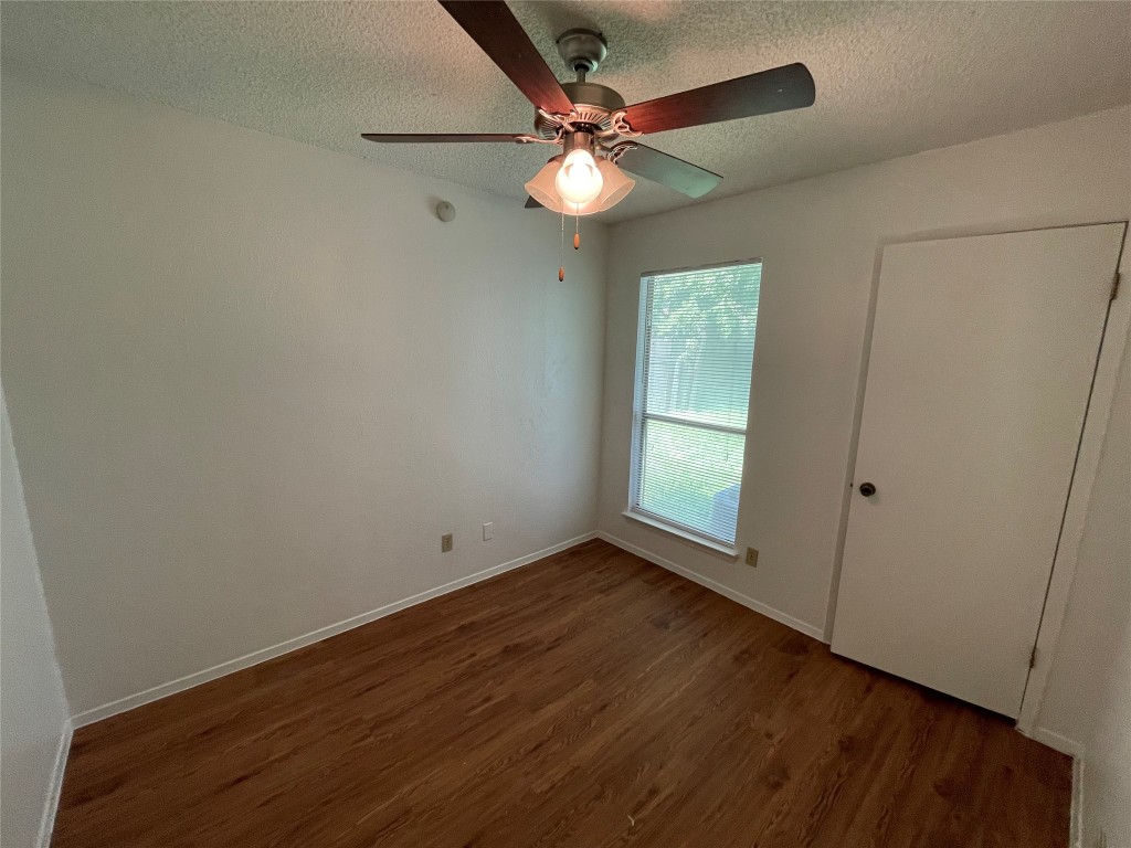 7506 St Amant Place Austin, TX 78749 - Photo 8 of 16 an empty room with wooden floor fan and windows