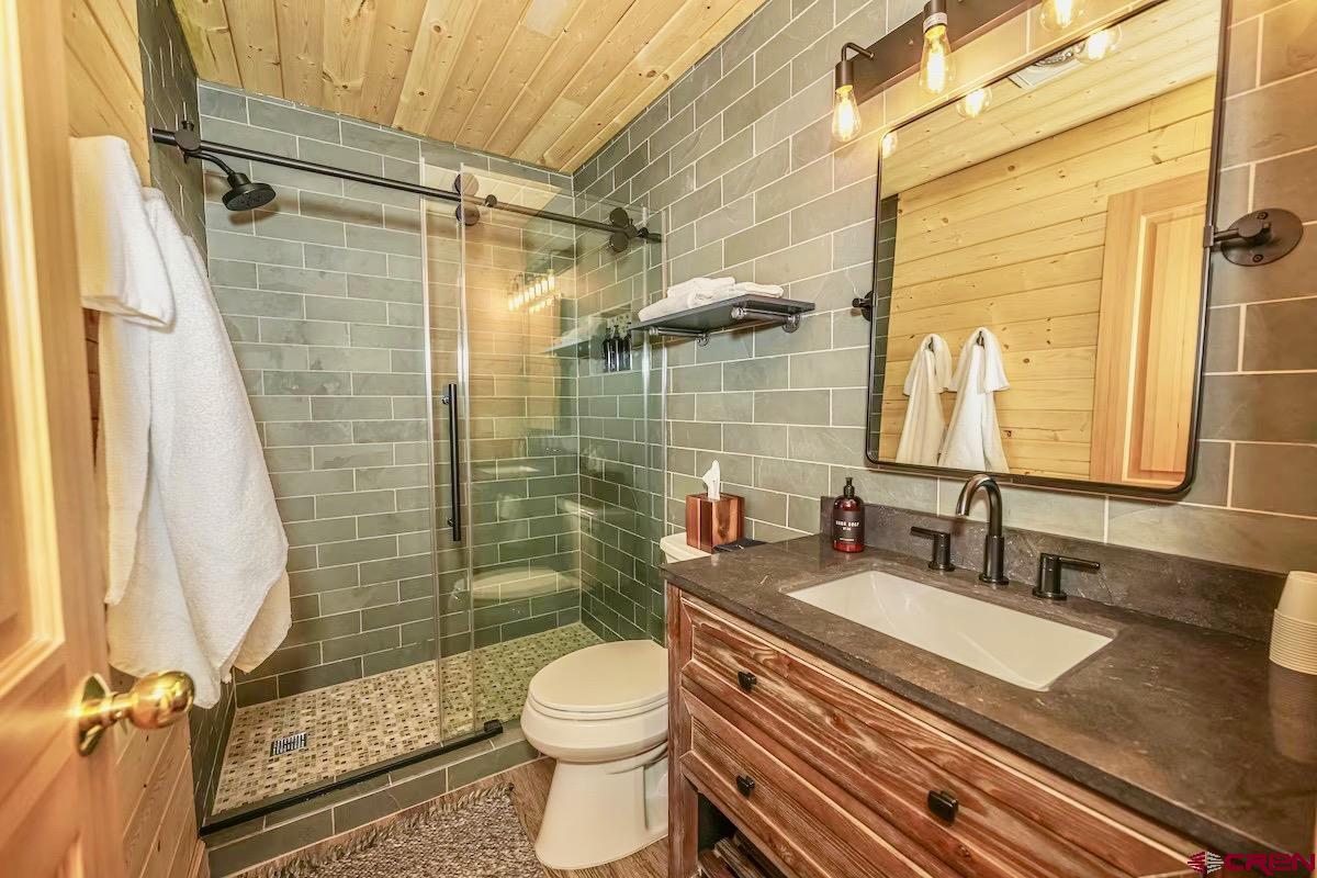 20 Hunter Hill Road, Unit 202 Crested Butte, CO 81225 - Photo 13 of 25 a bathroom with a granite countertop sink toilet a mirror and shower
