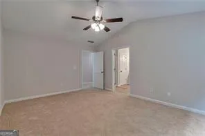 an empty room with a chandelier fan and windows