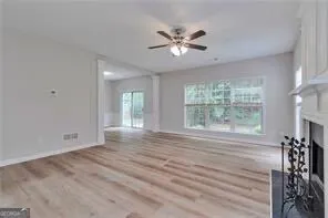 a view of an empty room with a window and wooden floor