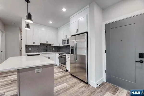 a kitchen with stainless steel appliances a refrigerator sink and microwave