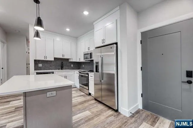 a kitchen with stainless steel appliances a refrigerator sink and microwave