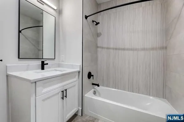 a bathroom with a tub sink and mirror