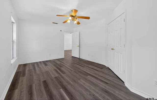 a view of an empty room with wooden floor