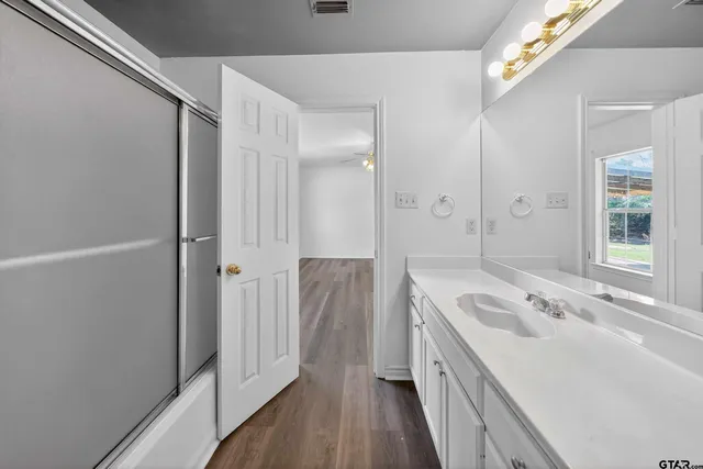 a spacious bathroom with a tub sink and mirror