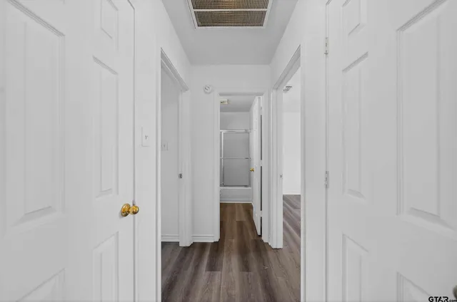 a view of a hallway with wooden floor and staircase