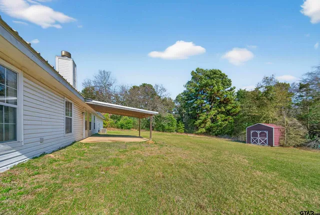 a view of an house with backyard space and balcony