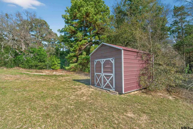 a view of a house with a yard and wooden fence