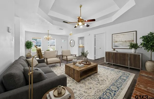 a living room with furniture a rug and a chandelier