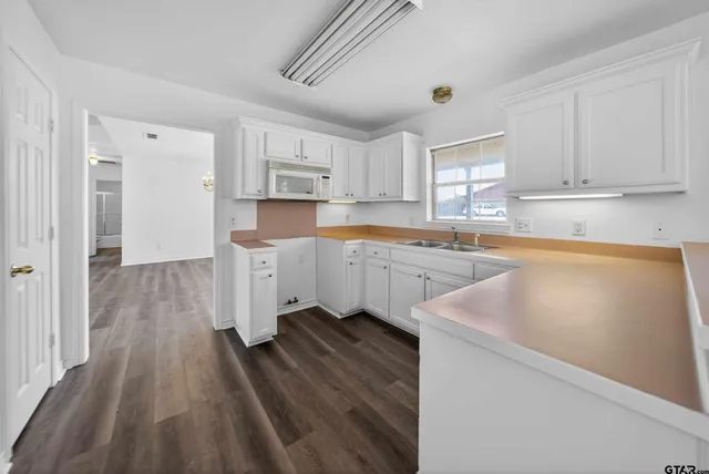 a kitchen with a sink window and cabinets