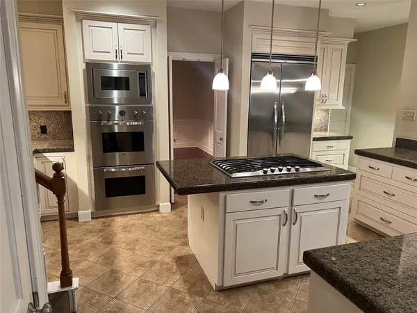 a kitchen with stainless steel appliances granite countertop a stove and a refrigerator