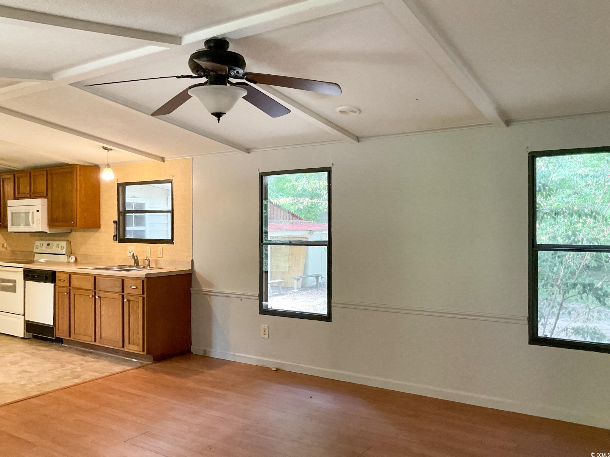 116 Putman Street Fountain Inn, SC 29644 - Photo 3 of 21 Kitchen with beamed ceiling, light countertops, brown cabinets, white appliances, and ceiling fan