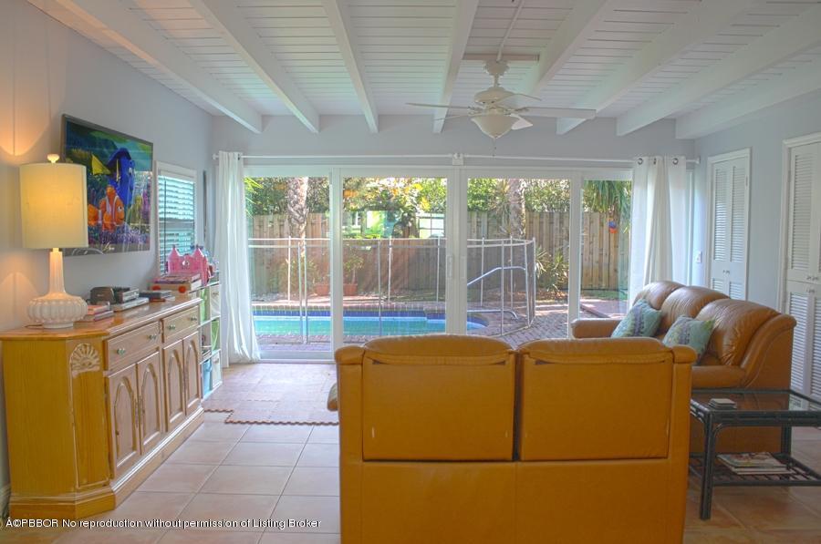 216 Costello Road West Palm Beach, FL 33405 - Photo 22 of 25 a living room with furniture a flat screen tv and a large window
