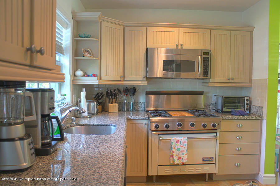 216 Costello Road West Palm Beach, FL 33405 - Photo 8 of 25 a kitchen with stainless steel appliances granite countertop a stove a sink and a microwave