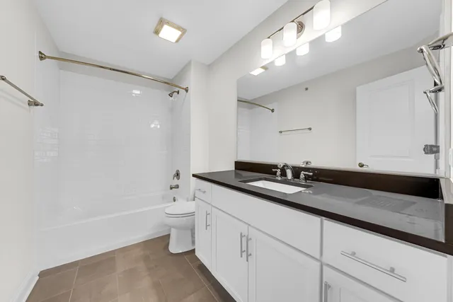 a bathroom with a double vanity sink toilet and shower