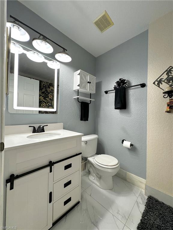3435 Randall Boulevard Naples, FL 34120 - Photo 12 of 20 a bathroom with a sink toilet and mirror