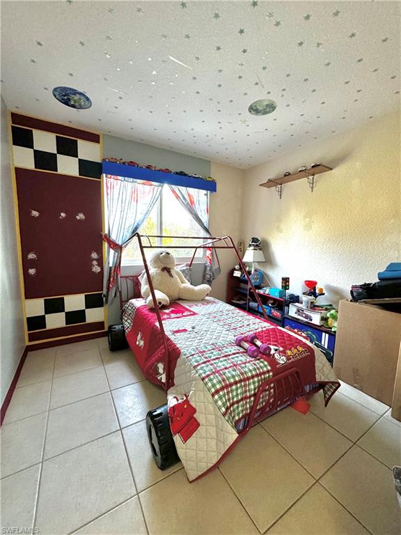 3435 Randall Boulevard Naples, FL 34120 - Photo 13 of 20 a bedroom with a bed and large windows