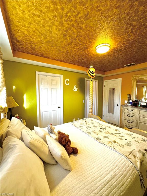 3435 Randall Boulevard Naples, FL 34120 - Photo 16 of 20 a large bedroom with a bed and a chandelier