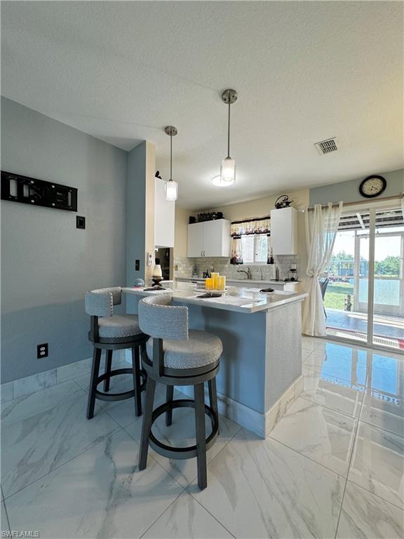 3435 Randall Boulevard Naples, FL 34120 - Photo 5 of 20 a kitchen with a sink and chairs