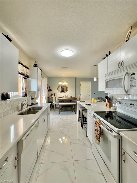 3435 Randall Boulevard Naples, FL 34120 - Photo 9 of 20 a kitchen with stainless steel appliances granite countertop a sink and stove top oven