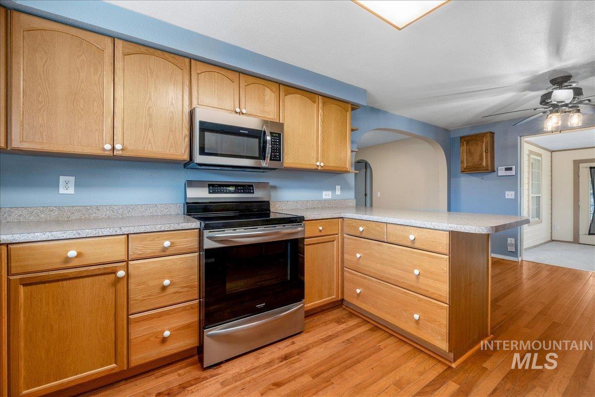 3002 Frozen Dog Road Emmett, ID 83617 - Photo 18 of 50 Kitchen featuring stainless steel appliances, light countertops, a peninsula, and ceiling fan