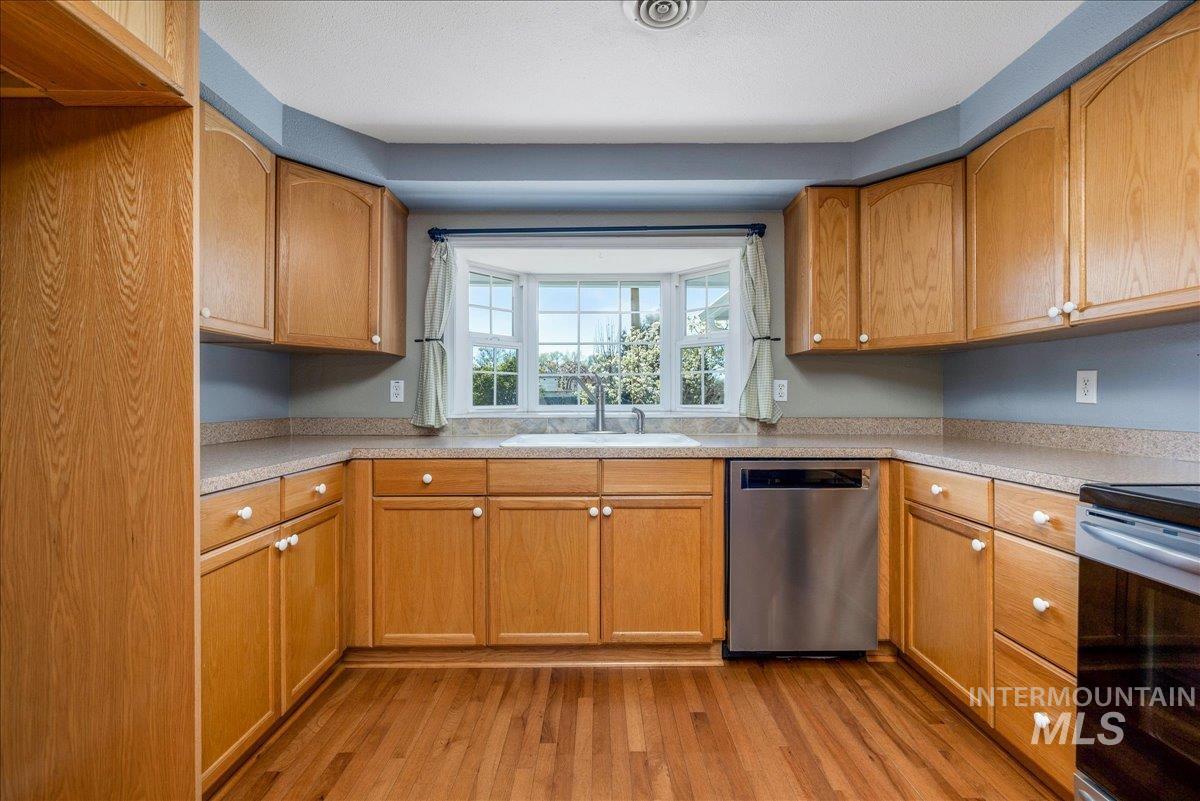 3002 Frozen Dog Road Emmett, ID 83617 - Photo 19 of 50 Kitchen featuring stainless steel appliances, light countertops, light wood finished floors, and wood finish cabinetry