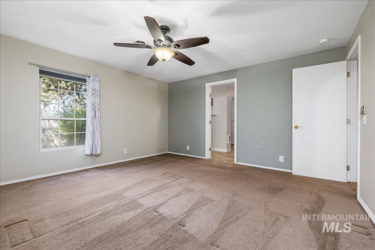 3002 Frozen Dog Road Emmett, ID 83617 - Photo 22 of 50 Unfurnished bedroom featuring a ceiling fan, a textured ceiling, and light carpet