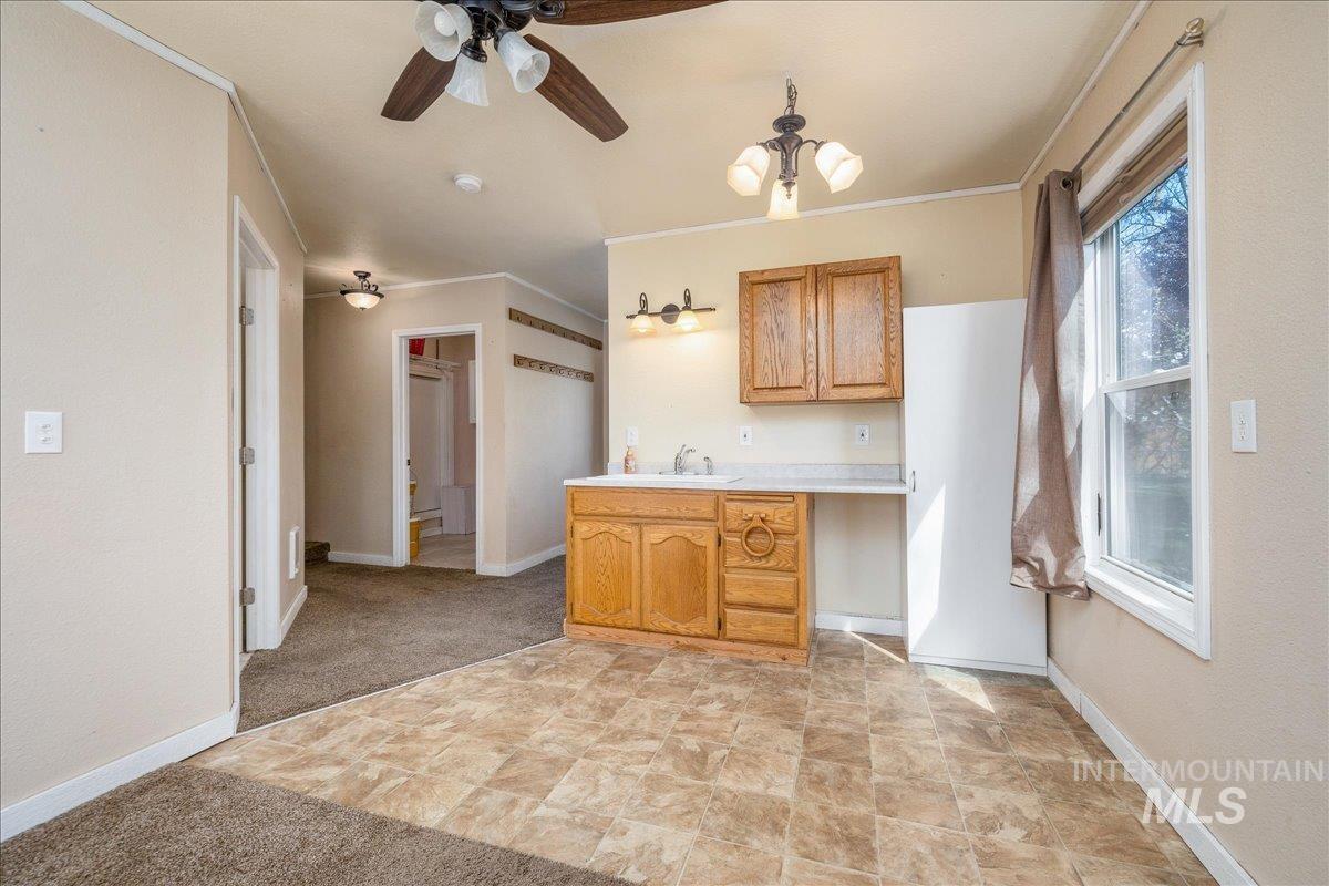 3002 Frozen Dog Road Emmett, ID 83617 - Photo 29 of 50 Kitchen featuring light countertops, crown molding, ceiling fan, stone finish floors, and wood finish cabinets