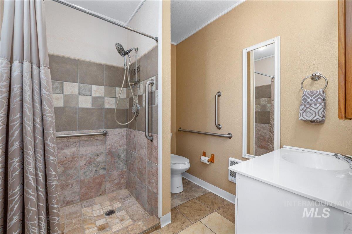 3002 Frozen Dog Road Emmett, ID 83617 - Photo 31 of 50 Bathroom featuring vanity, a stall shower, light tile patterned floors, and a textured wall