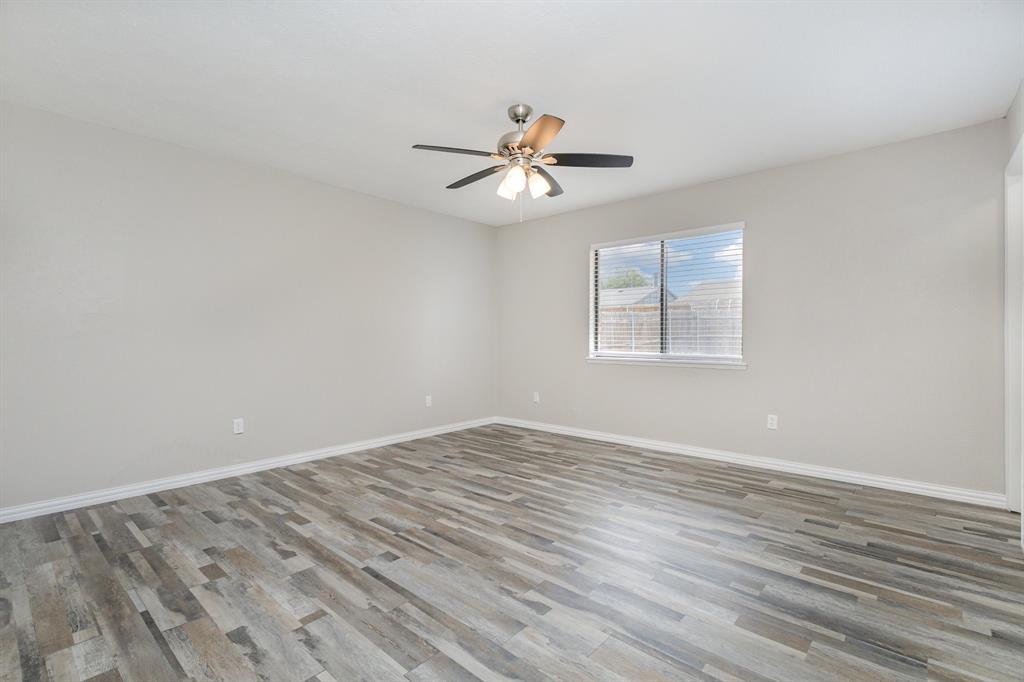 5513 Rearn Drive The Colony, TX 75056 - Photo 12 of 19 an empty room with wooden floor ceiling fan and window