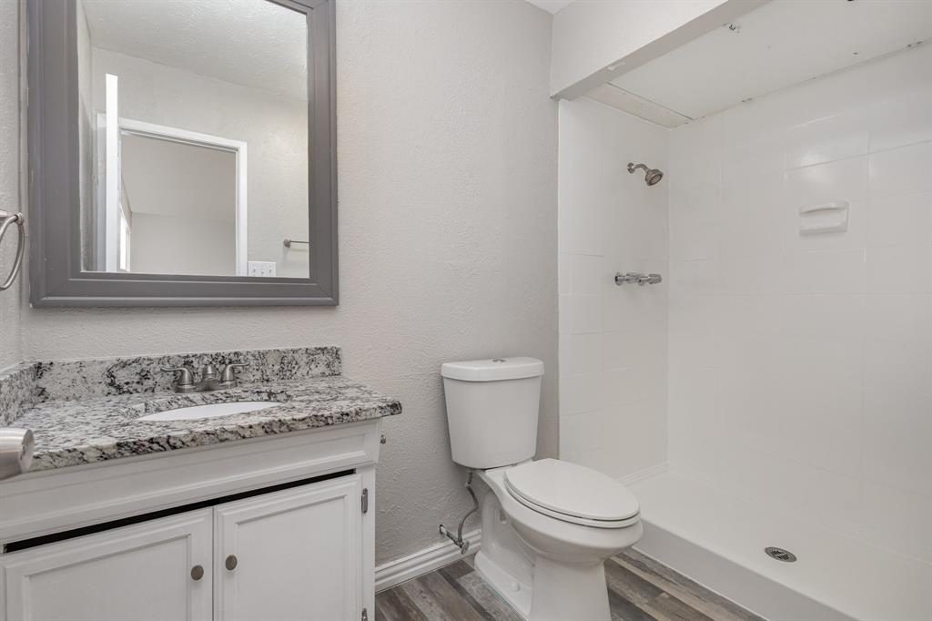 5513 Rearn Drive The Colony, TX 75056 - Photo 13 of 19 a bathroom with a granite countertop toilet sink and mirror