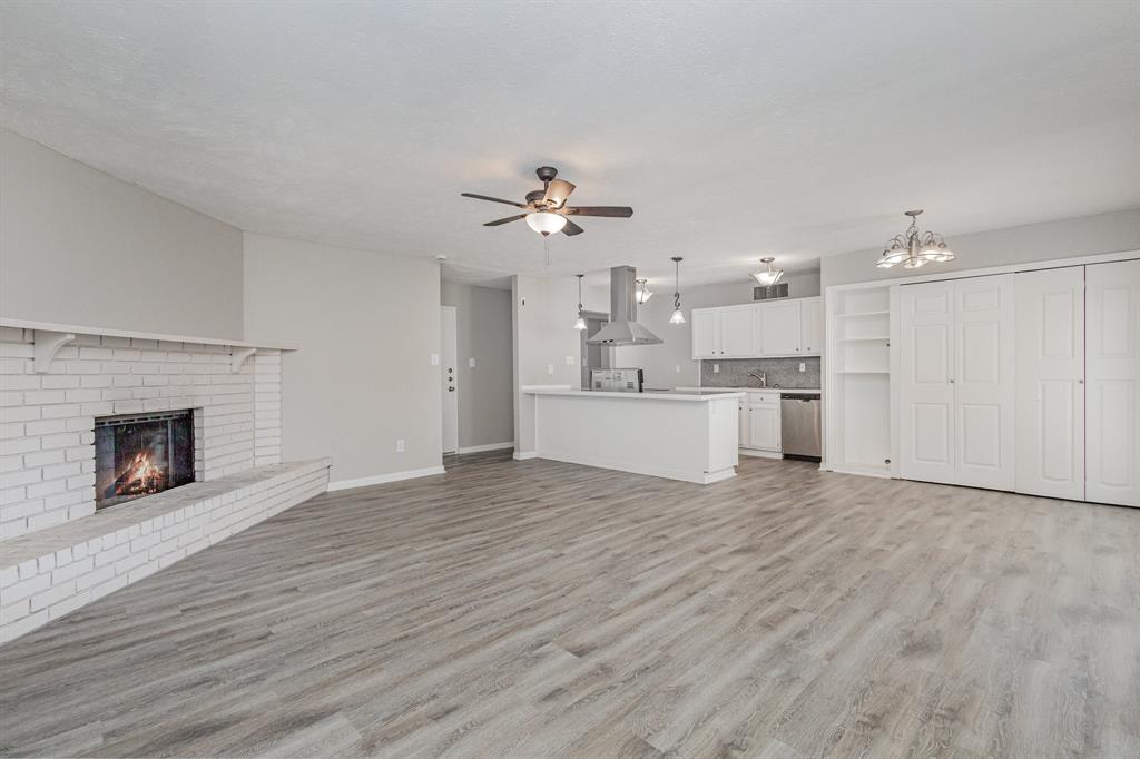 5513 Rearn Drive The Colony, TX 75056 - Photo 6 of 19 a view of a livingroom with a fireplace a ceiling fan and windows