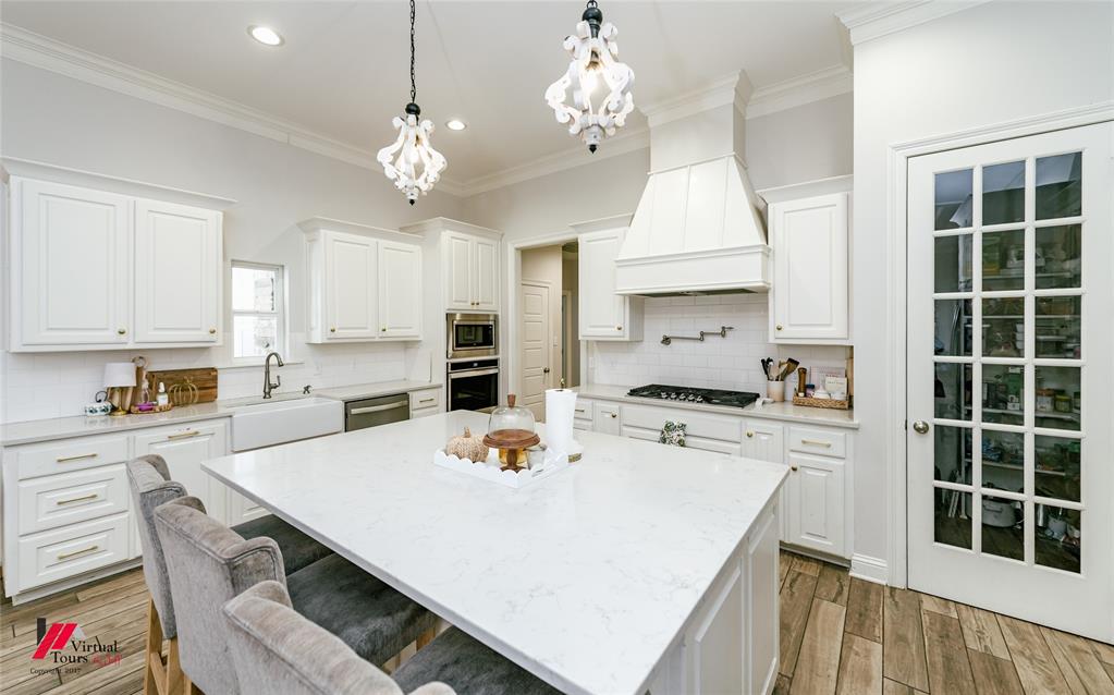 327 Ramsey Road Stonewall, LA 71078 - Photo 14 of 40 a kitchen with a stove a refrigerator and a dining table with wooden floor