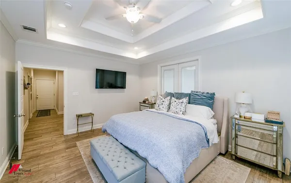 a bedroom with a bed and a flat tv screen on dresser