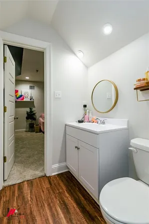 a bathroom with a granite countertop toilet sink and mirror