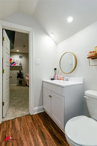 a bathroom with a granite countertop toilet sink and mirror